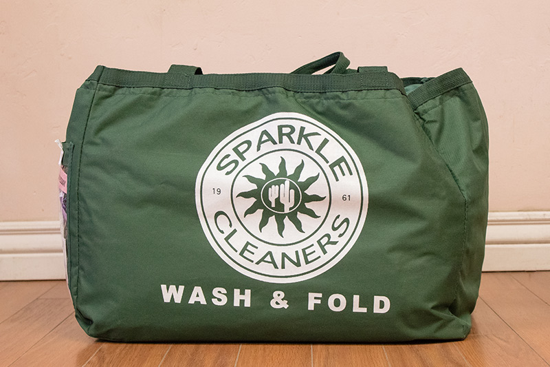A green tote bag labeled 